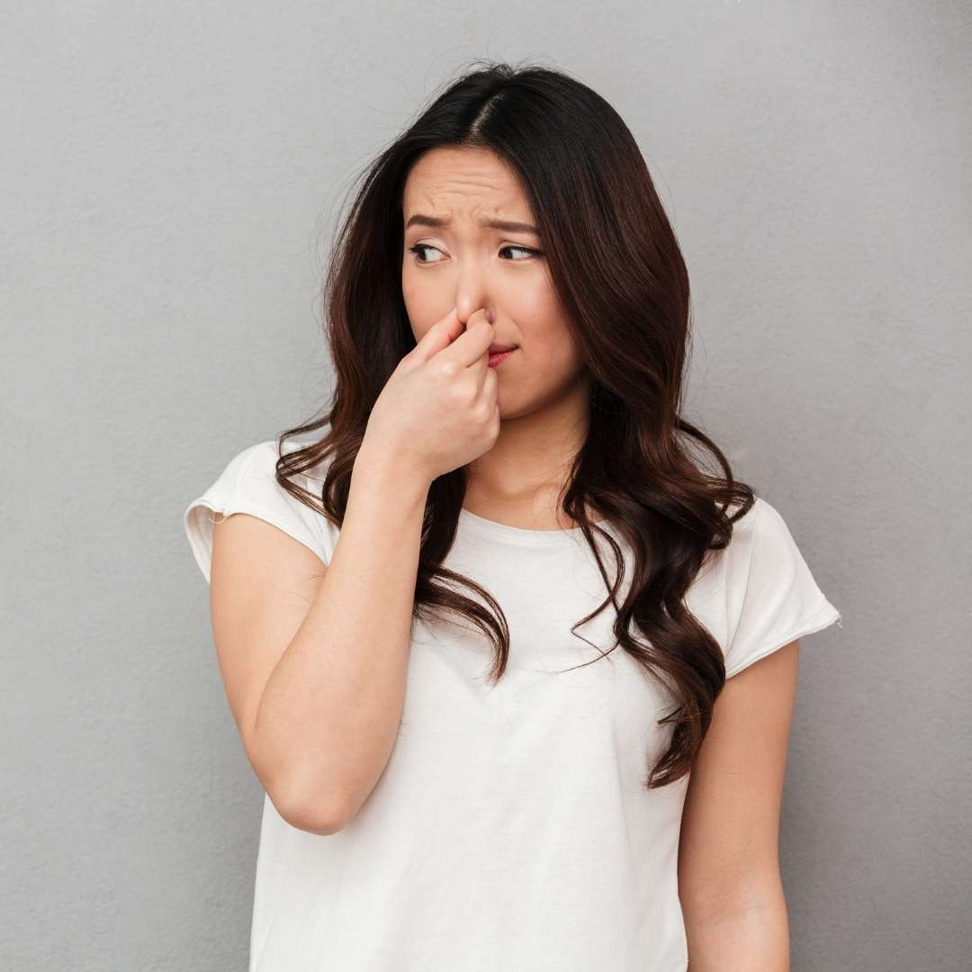 Woman holding her nose as if something smells bad