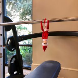 Elf on the shelf hanging from fitness bar