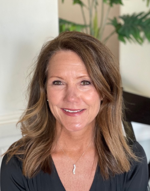 Image of woman with brown hair smiling and looking at the camera