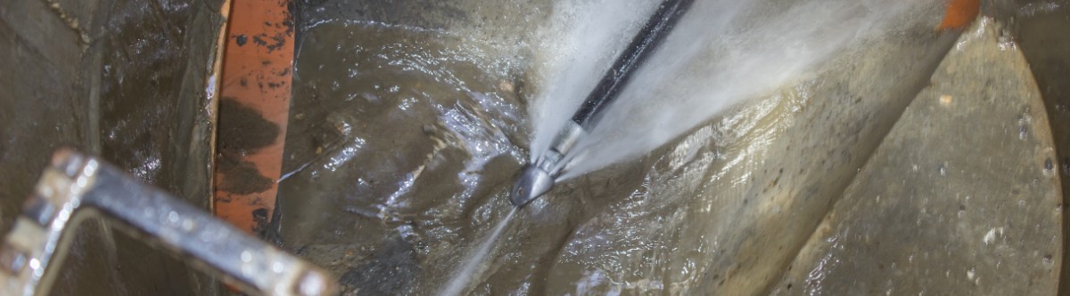 Image of a commercial sewer line being cleaned with high-power water jet