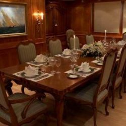Image of wooden dining interior with 10-person table custom made by Dennis Boatworks.