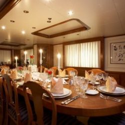 An image of an extravagant custom interior dining room with a 12-person dining table with Dennis Boatworks.