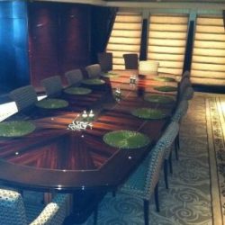 An image of a custom interior below deck dining room with a 12-person dining table built by Dennis Boatworks.