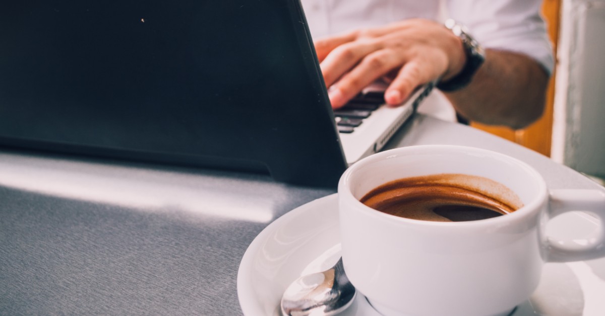 Photo of someone drinking coffee next to a computer by AndriyKo Podilnyk on Unsplash