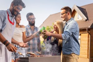 people chatting and eating and drinking together in the backyard