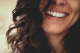 A close up photo of a woman smiling.