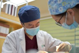 A man wearing a face mask performs dental surgery on a patient. Photo by H Shaw on Unsplash.