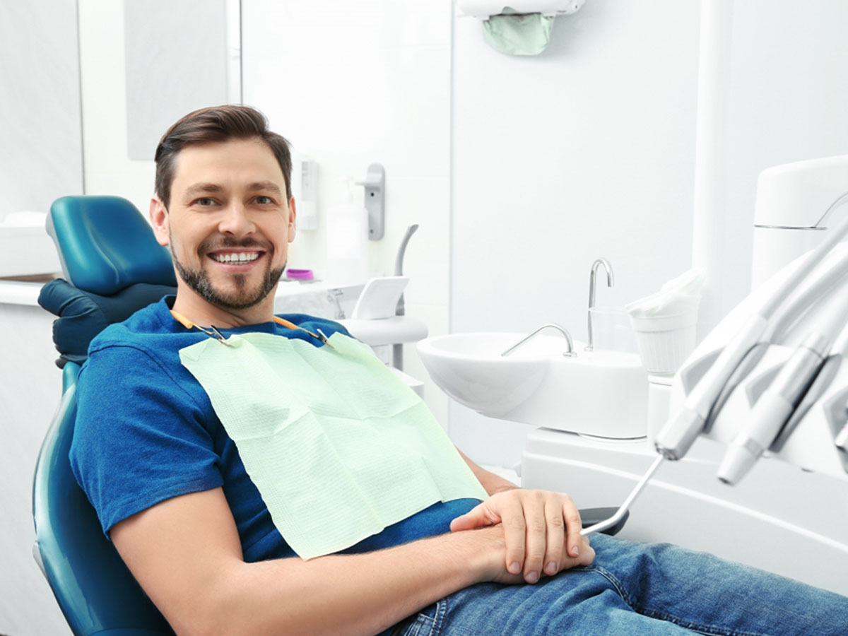 : Happy man having dentist's appointment in modern office