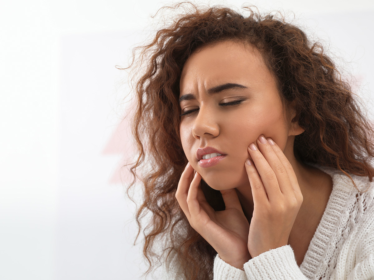 A woman feeling numbness in her cheeks