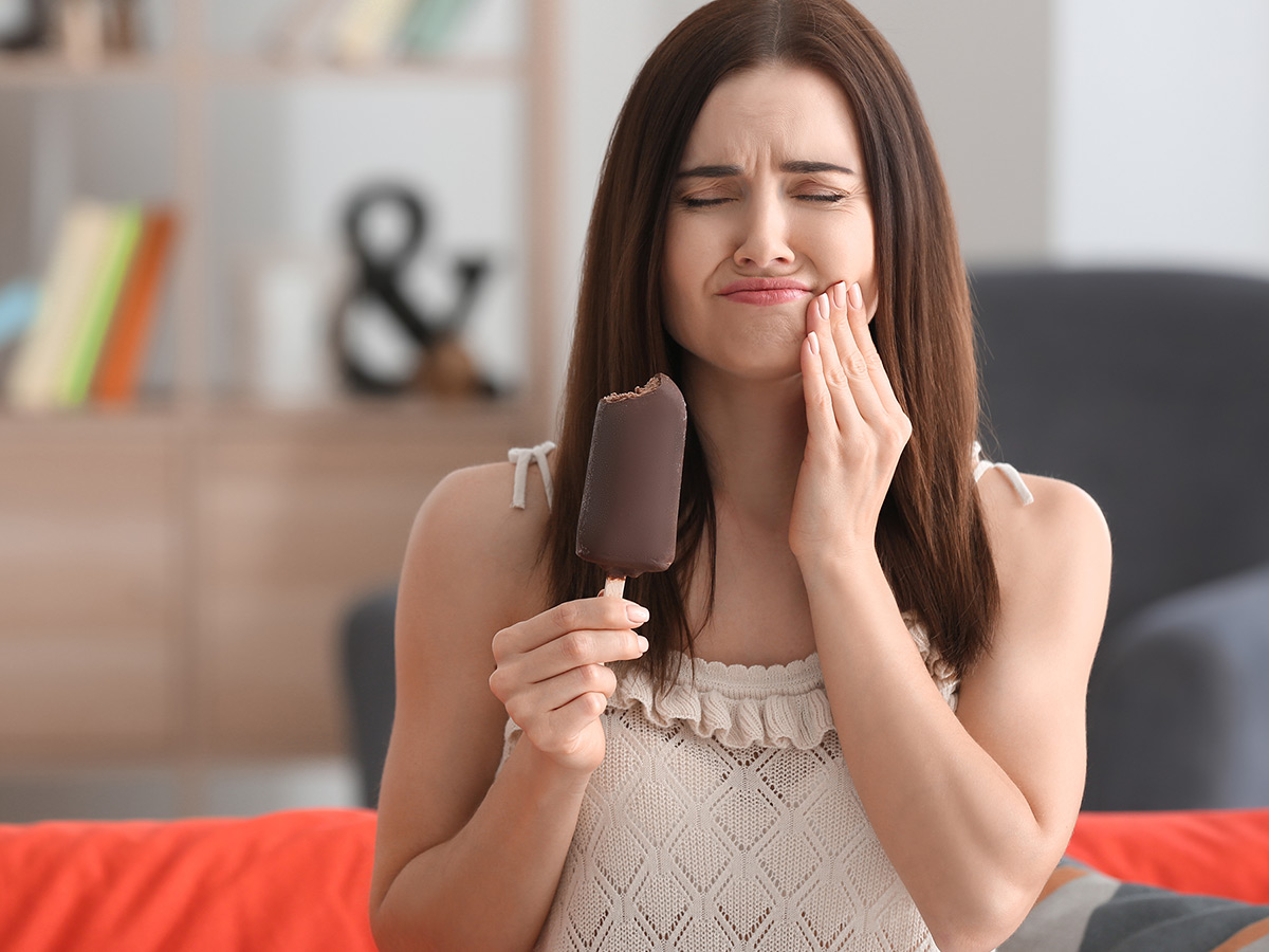 A woman feeling tooth pain after eating ice cream