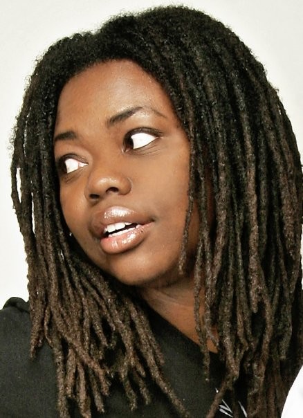 Woman with dreads looking to the left.