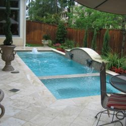 Patio with custom pool featuring two sections and water features - Hipp Pools