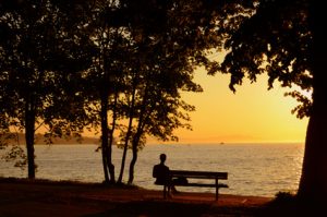 Man Sitting On Bench During A Beautiful Sunset