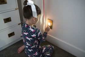 Picture of little girl using the built in night light. You push the on the light and a portable flash light pops out.