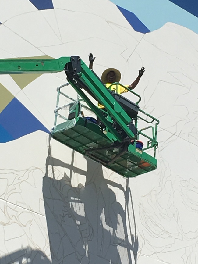Zulu Painter Waves Greeting from lift