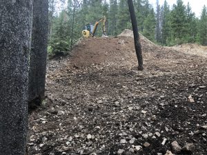 Mini excavator atop a pile of soil