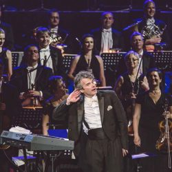 Randall Craig Fleischer conducting the orchestra that performs with classic rock and classical music show Rocktopia.