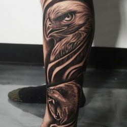 Black and gray realism tattoo of an eagle and bear on the left leg.