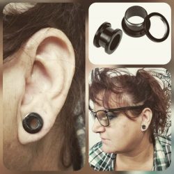 Double zero gauge piercing with black stainless steel tunnels.