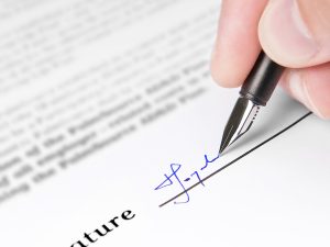 Image of a person signing a document