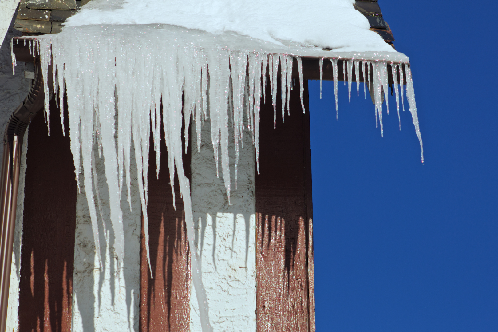 large, sharp icicles hanging off of a gutter