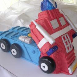Optimus Prime Transformer | Transformers Birthday Cakes | Specialty Cakes, sculpted cakes in southlake, 3-d cakes in arlington, sculpted cakes in arlington, dallas 3-d cake bakery, sculpted cakes in fort worth, sculpted cakes in dallas, sculpted cakes in plano, frisco sculpted cakes, 3-d cakes, sculpted cakes in Irving, sculpted cakes in Grand Prairie
