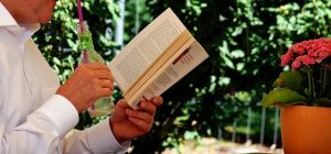 man reading while having a drink